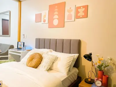 a bedroom with a bed with white sheets and pillows at BGC's Best Condo Near Uptown Mall #oursw15o in Manila