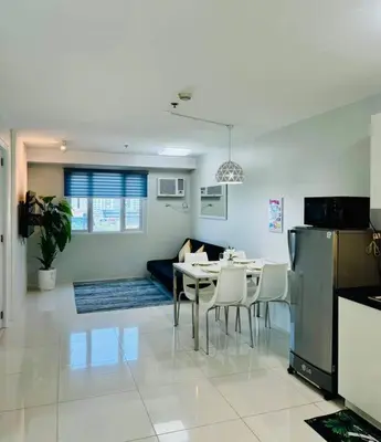 a kitchen and dining room with a table and chairs at Cozy Minimalist 2BR Condo at Princeton QC near Rob Magnolia in Manila