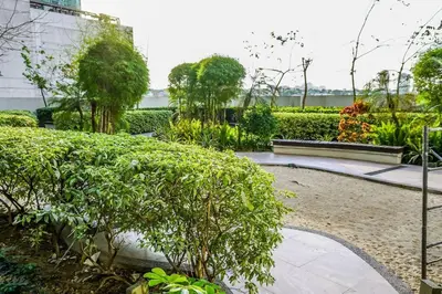 a garden with bushes and trees and a walkway at New Modern Luxurious 2Bedroom in Eastwood in Manila