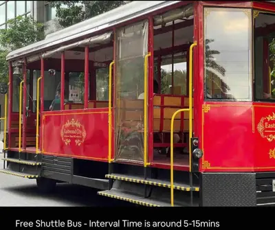 a red trolley car driving down the street at New Modern Luxurious 2Bedroom in Eastwood in Manila