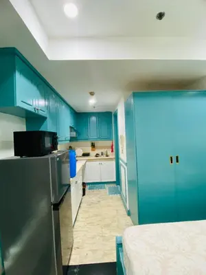 a kitchen with blue cabinets and a stainless steel refrigerator at Baywatch Tower in Manila