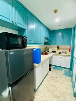 a kitchen with blue cabinets and a stainless steel refrigerator at Baywatch Tower in Manila