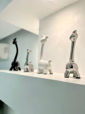 a shelf with a group of sculptures on it at Thompson Suites Fort Victoria Tower BGC Loft Type 1BR in Manila