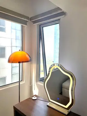 a mirror sitting on a table next to a window at Thompson Suites Fort Victoria Tower BGC Loft Type 1BR in Manila