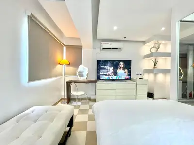 a bedroom with a bed and a tv in it at Thompson Suites Fort Victoria Tower BGC Loft Type 1BR in Manila