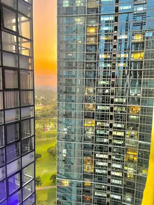 a tall building with many windows at night at Thompson Suites Fort Victoria Tower BGC Loft Type 1BR in Manila