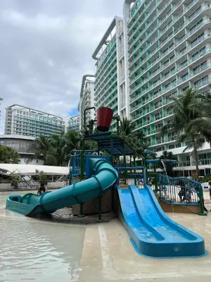 a water slide in a water park in front of a building at The Solaris Point with Pool View in Manila