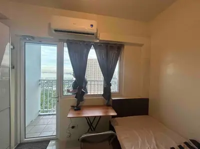 a room with a bed and a window with a balcony at Condo with Bayview in Manila (along Roxas Boulevard) in Manila