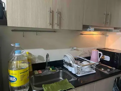 a kitchen sink with a dish drying rack next to it at Condo with Bayview in Manila (along Roxas Boulevard) in Manila