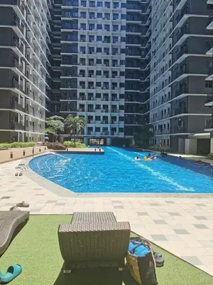 a large swimming pool in front of tall buildings at Mall of Asia condotel in Manila