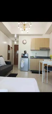 a kitchen and a living room with a couch and a table at Condo in Makati studio type fast wifi Netflix in Manila