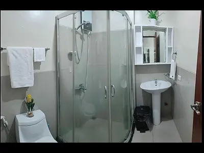 a bathroom with a shower and a toilet and a sink at Condo in Makati studio type fast wifi Netflix in Manila