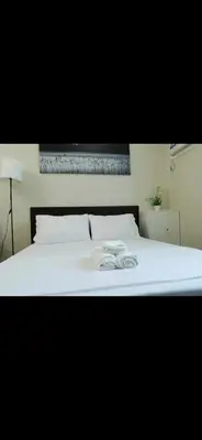 a white bed with a pair of shoes on it at Condo in Makati studio type fast wifi Netflix in Manila