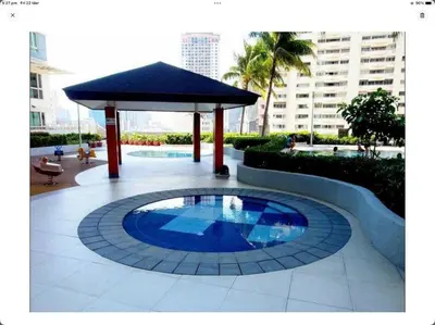 a small blue pool in a courtyard with a gazebo at Condo in Makati studio type fast wifi Netflix in Manila