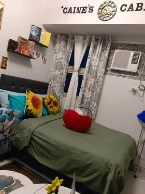 a bedroom with a bed with pillows and a window at Caine's Cabin 27th Feel our Love and Warmth Welcome in Manila