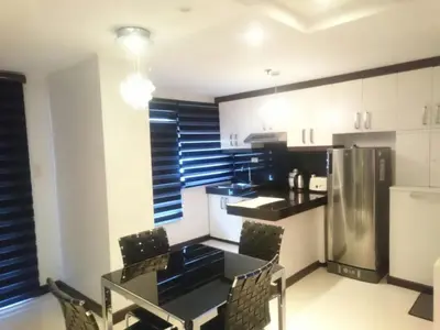 a kitchen with a table and chairs and a refrigerator at ADB AVENUE TOWER in Manila