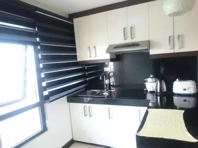 a kitchen with black and white cabinets and a window at ADB AVENUE TOWER in Manila
