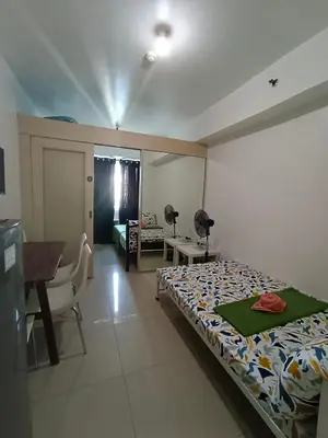 a bedroom with a bed and a table and a desk at 1BR SEA RESIDENCE by ABBY in Manila