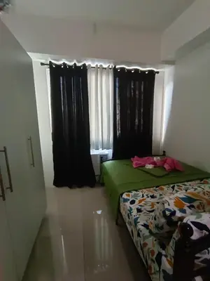 a bedroom with a bed and a window with black curtains at 1BR SEA RESIDENCE by ABBY in Manila