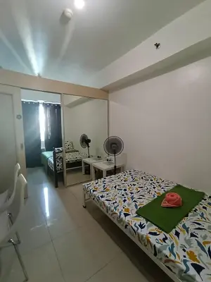a bedroom with a bed and a desk and a mirror at 1BR SEA RESIDENCE by ABBY in Manila