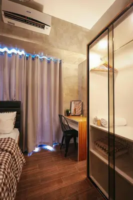 a bedroom with a bed and a desk with a window at Kensal Industrial - Air Residences in Manila