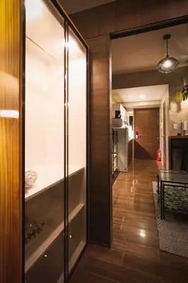 a living room with a glass door and a kitchen at Kensal Industrial - Air Residences in Manila