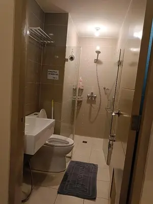 a bathroom with a shower and a toilet and a sink at Rj Condotel Near Naia Terminal 3 in Manila