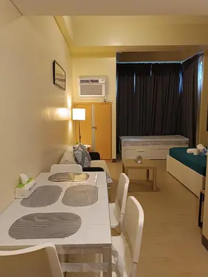 a room with two beds and a table and a couch at Rj Condotel Near Naia Terminal 3 in Manila