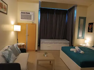 a living room with a bed and a couch at Rj Condotel Near Naia Terminal 3 in Manila