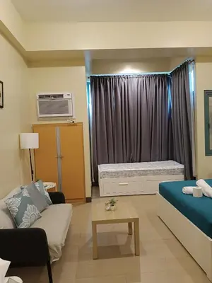 a living room with a bed and a couch at Rj Condotel Near Naia Terminal 3 in Manila