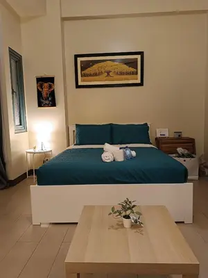 a bedroom with a bed and a wooden table at Rj Condotel Near Naia Terminal 3 in Manila