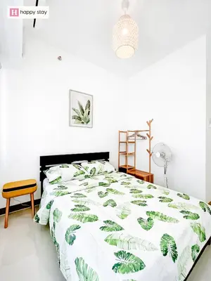 a bedroom with a bed with a green and white comforter at Happy Stay in Manila