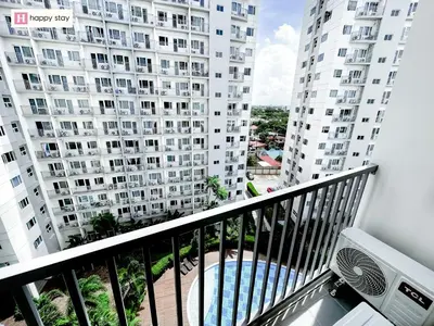a balcony with a view of a pool and buildings at Happy Stay in Manila