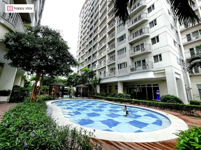 a person in a pool in front of a building at Happy Stay in Manila