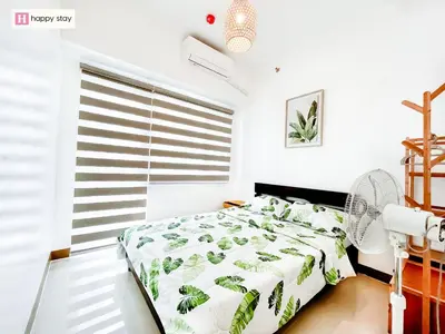 a bedroom with a bed with a green and white comforter at Happy Stay in Manila