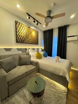 a living room with a bed and a couch at Fullerton Suites in Puting Kahoy