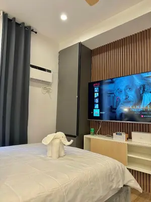 a bedroom with a bed with a stuffed elephant on it at Fullerton Suites in Puting Kahoy