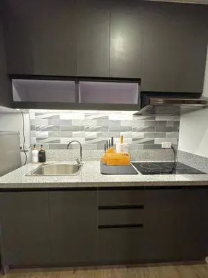 a kitchen with a sink and a counter top at Fullerton Suites in Puting Kahoy
