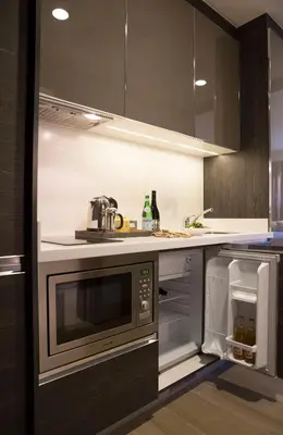 a kitchen with a microwave and a sink at Makati Diamond Residences in Manila