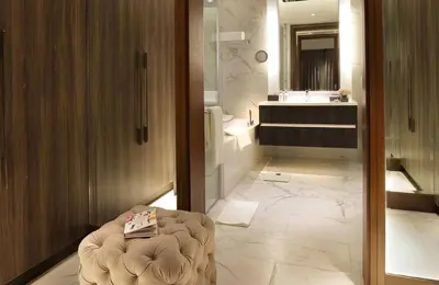 a bathroom with a toilet and a sink and a mirror at Makati Diamond Residences in Manila