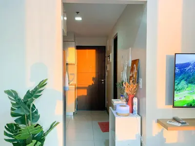 a room with a hallway with a tv on a wall at Best BGC Condo Near Uptown Area #oursw30b2 in Manila