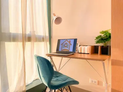 a desk with a laptop on a table with a chair at Best BGC Condo Near Uptown Area #oursw30b2 in Manila
