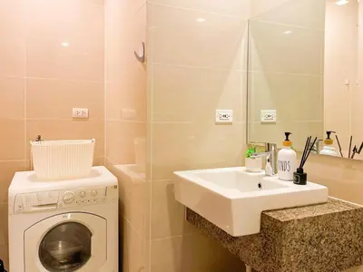 a bathroom with a washing machine and a sink at Best BGC Condo Near Uptown Area #oursw30b2 in Manila