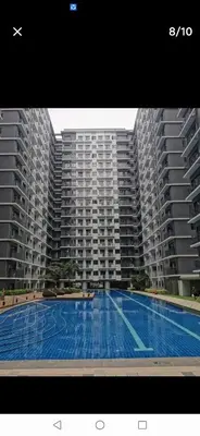 a large swimming pool in front of two large buildings at Shore 3 mall of Asia condotel in Manila
