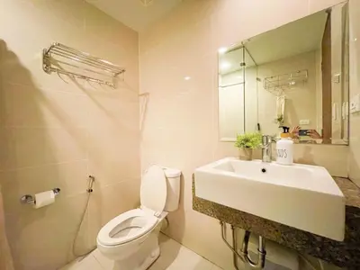 a bathroom with a sink and a toilet and a mirror at BGC Stay: Prime Condo AcrossGrand Hyatt #oursw32p in Manila