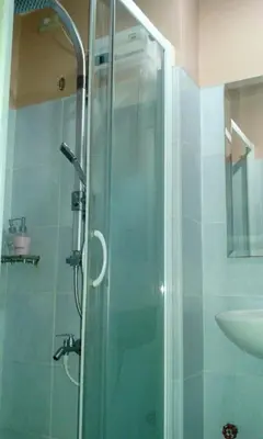 a glass shower in a bathroom with a sink at Sea Residences Holiday Rentals in Manila