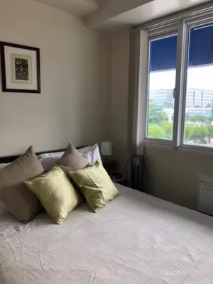 a bedroom with a bed with two pillows and a window at Sea Residences Holiday Rentals in Manila