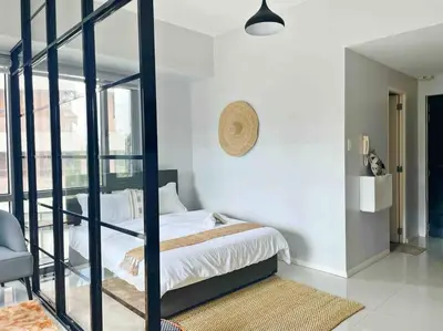 a bedroom with a bed and a glass wall at Gora studio in Avant BGC parking with fee in Manila