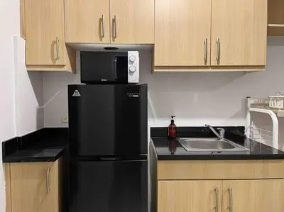 a kitchen with a black refrigerator and a sink at Gora studio in Avant BGC parking with fee in Manila