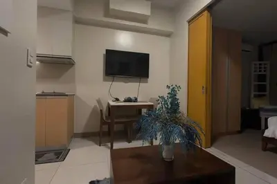 a living room with a tv and a vase on a table at #31 One Uptown Residences BGC in Manila